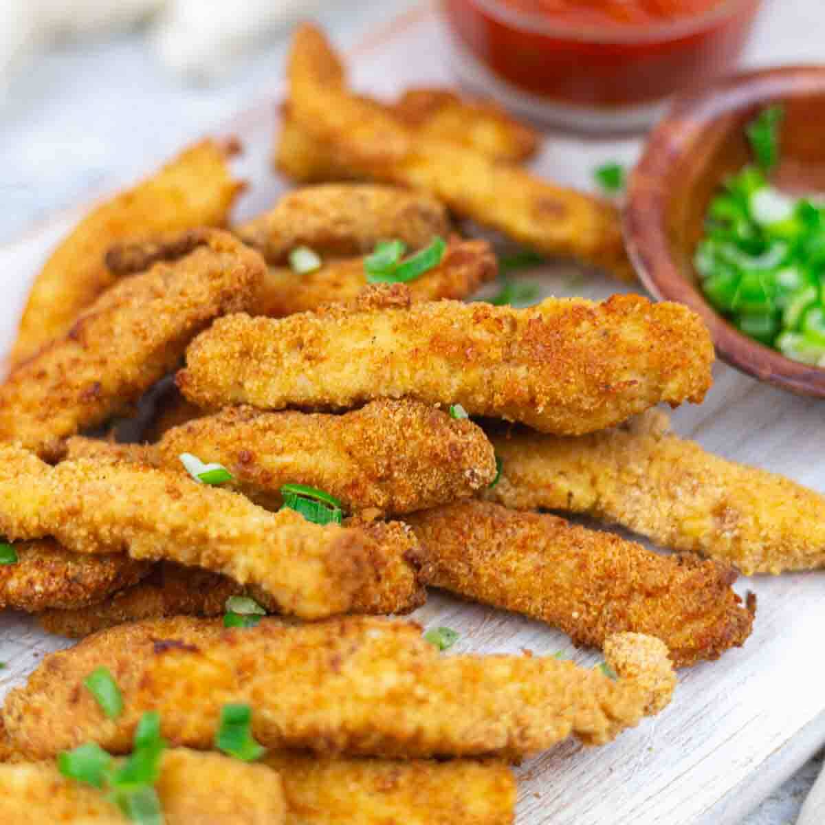 Air fried chicken strips garnished with green onions.