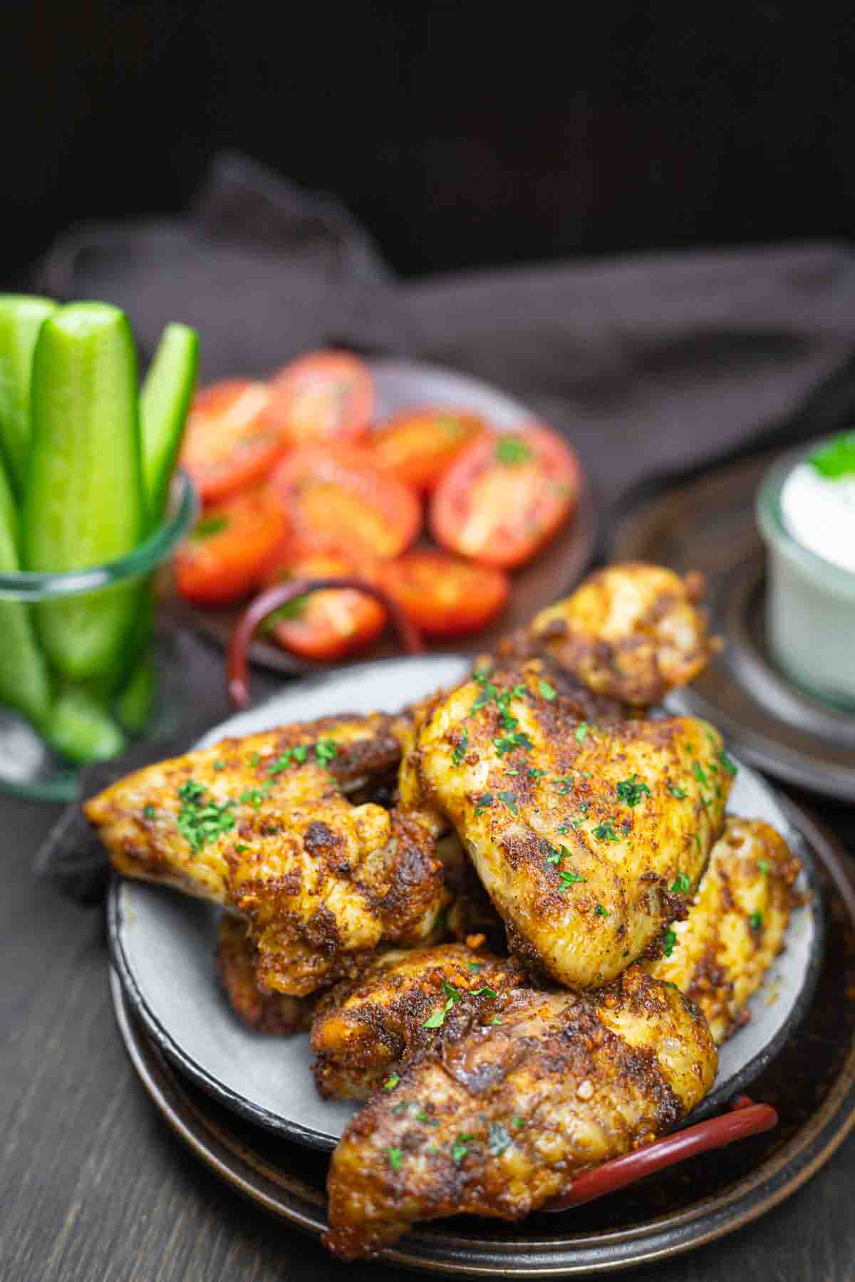 Golden crispy wings on plate with garnishes.