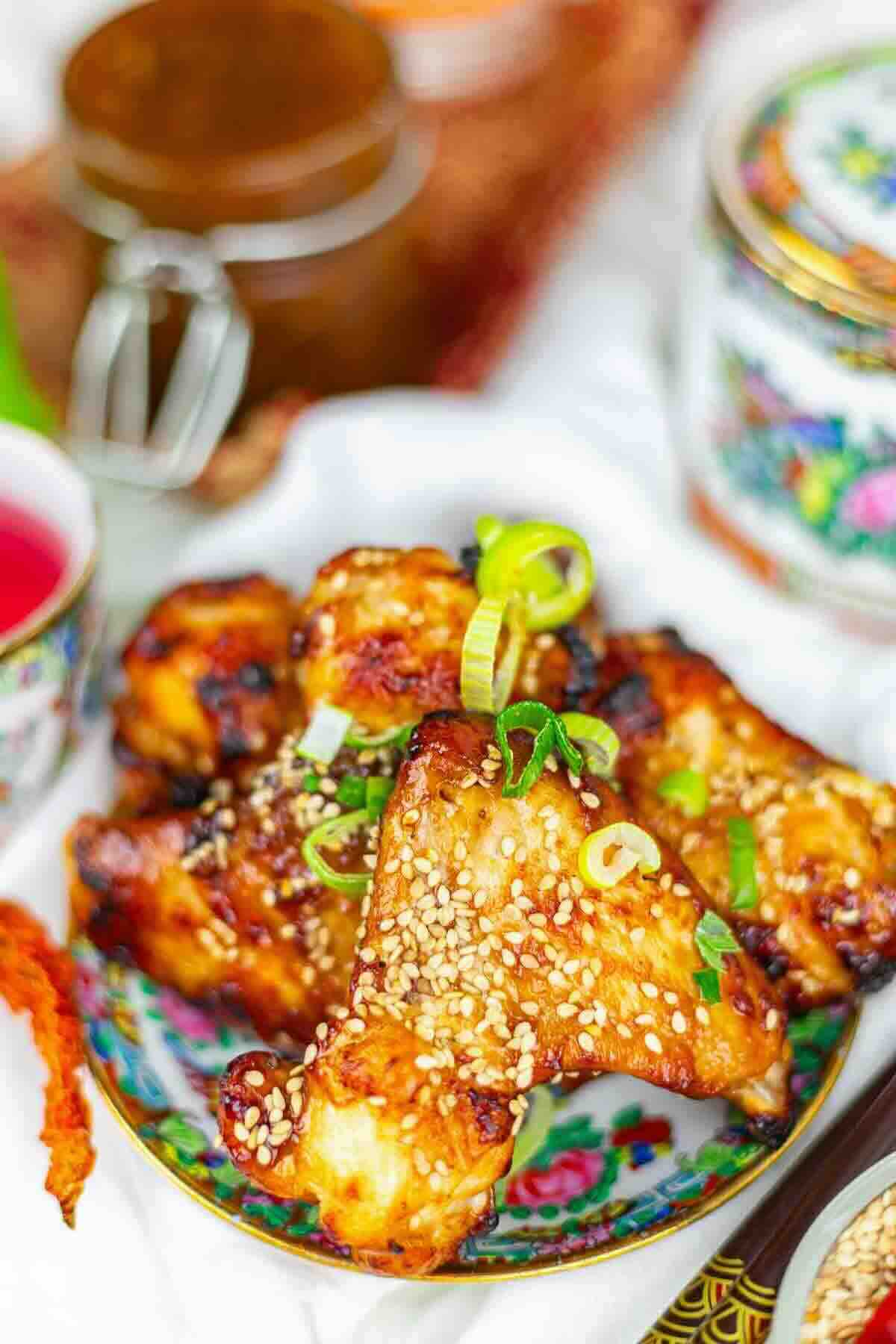 Sweet BBQ wings arranged on floral dish.