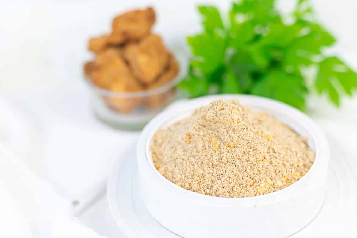 Bowl of breading mix with parsley background.