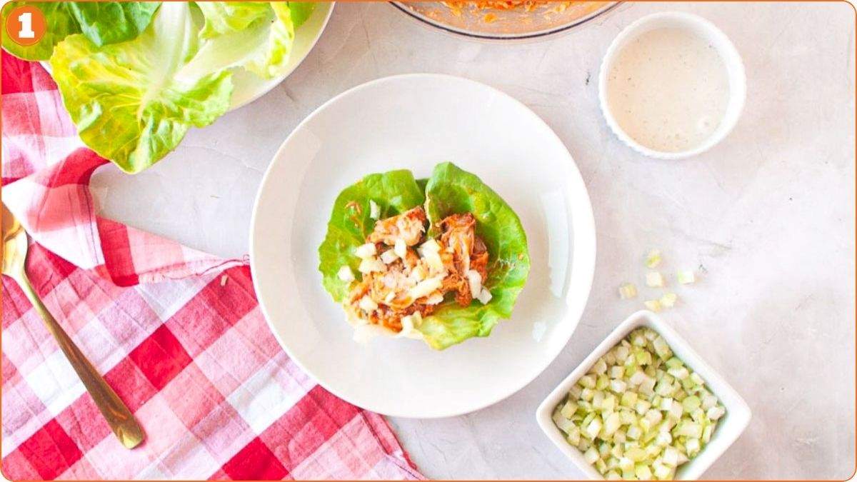 Adding celery and sauce to lettuce wraps.