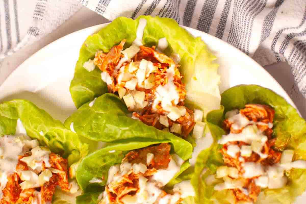 Buffalo chicken lettuce wraps topped with dressing.