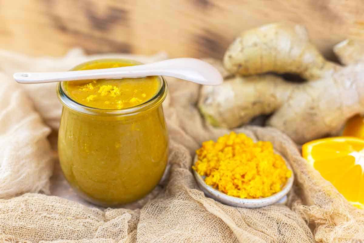 Chicken orange sauce jar with ginger background.