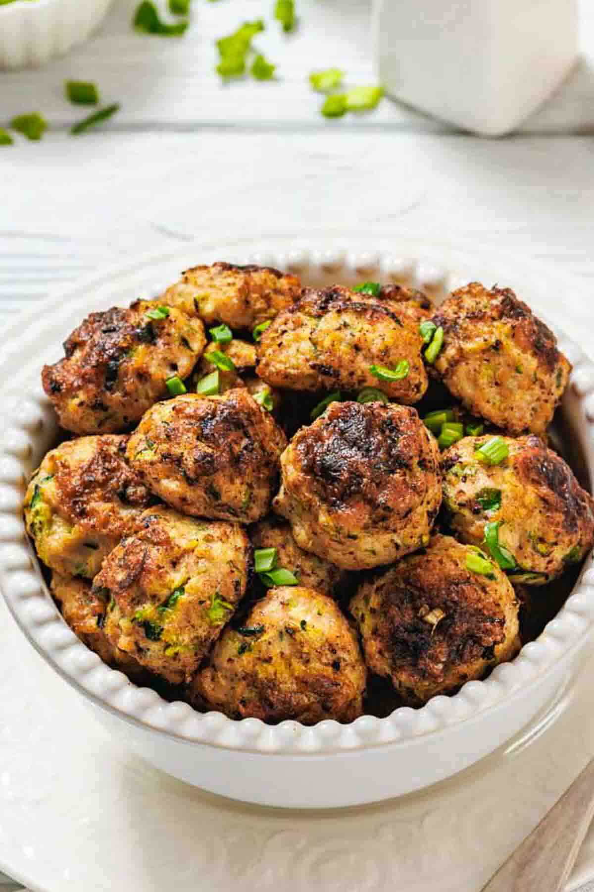 Golden chicken fritters garnished with green onions.