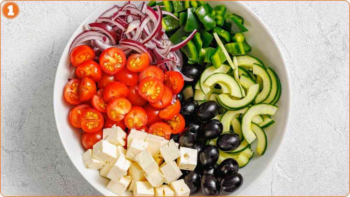 Chopped vegetables and feta arranged in bowl.