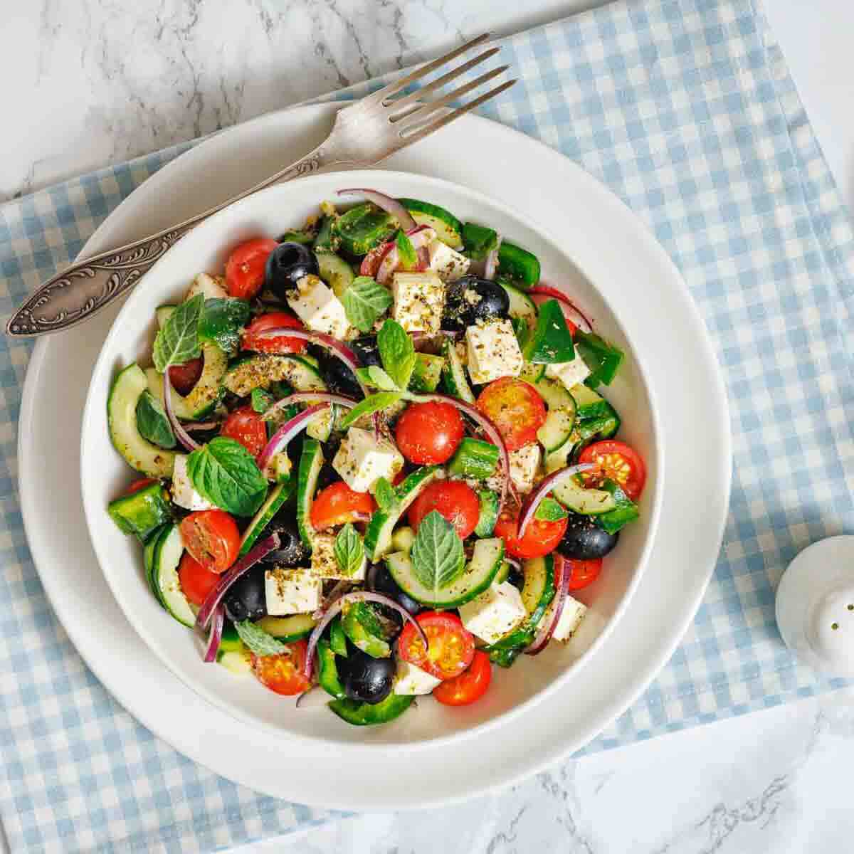 Summer salad with cucumbers tomatoes olives and feta.