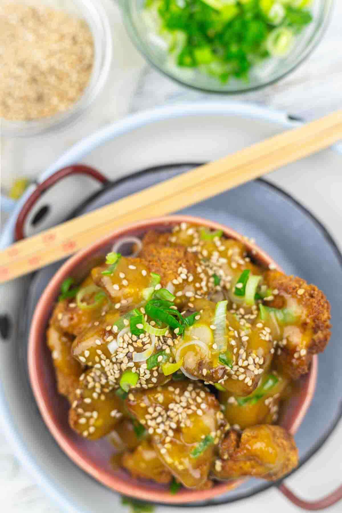 Top view of orange chicken with green onions.
