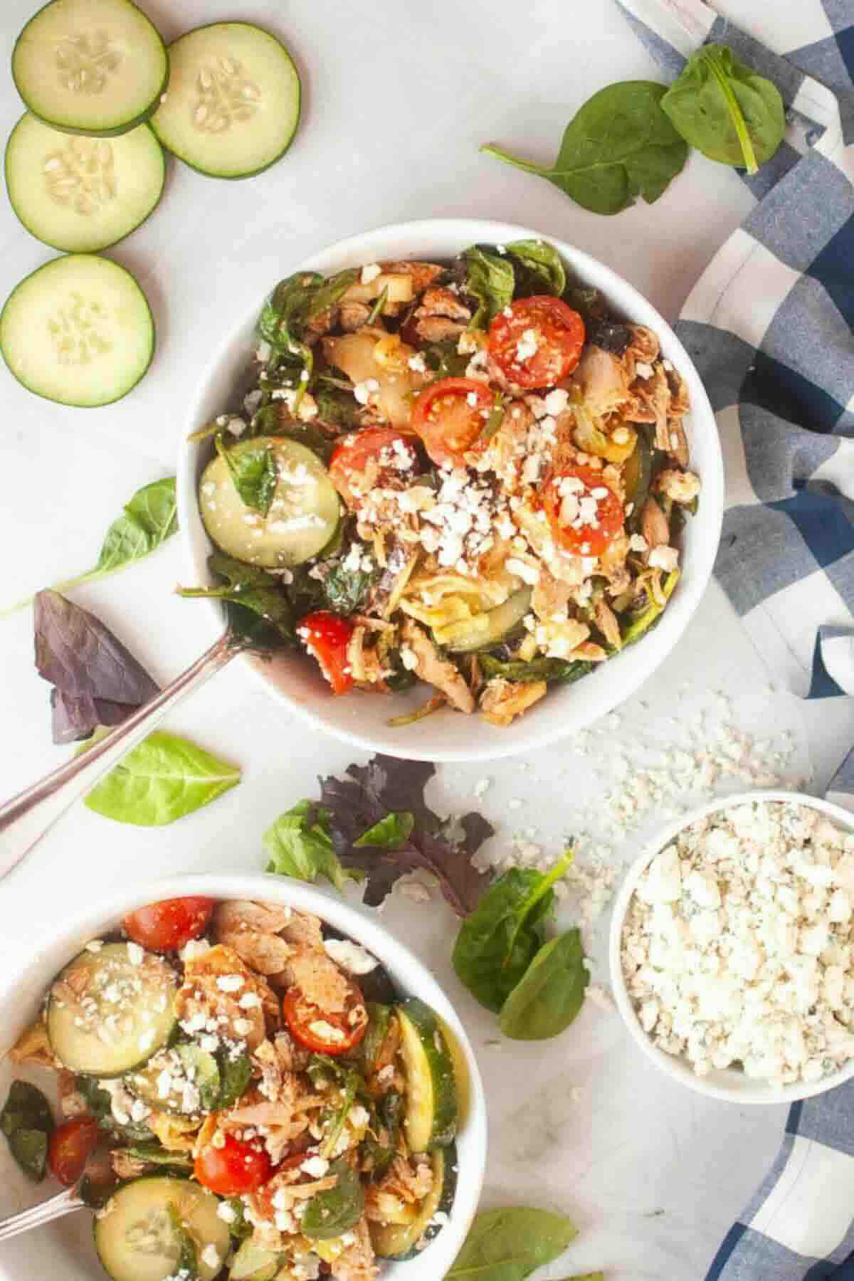 Two bowls of buffalo chicken salad served.