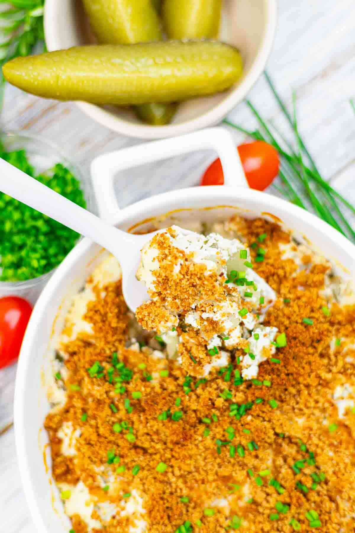 Spoonful of creamy casserole with breadcrumbs topping.