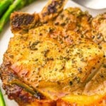 Air fryer pork chop on plate with asparagus.