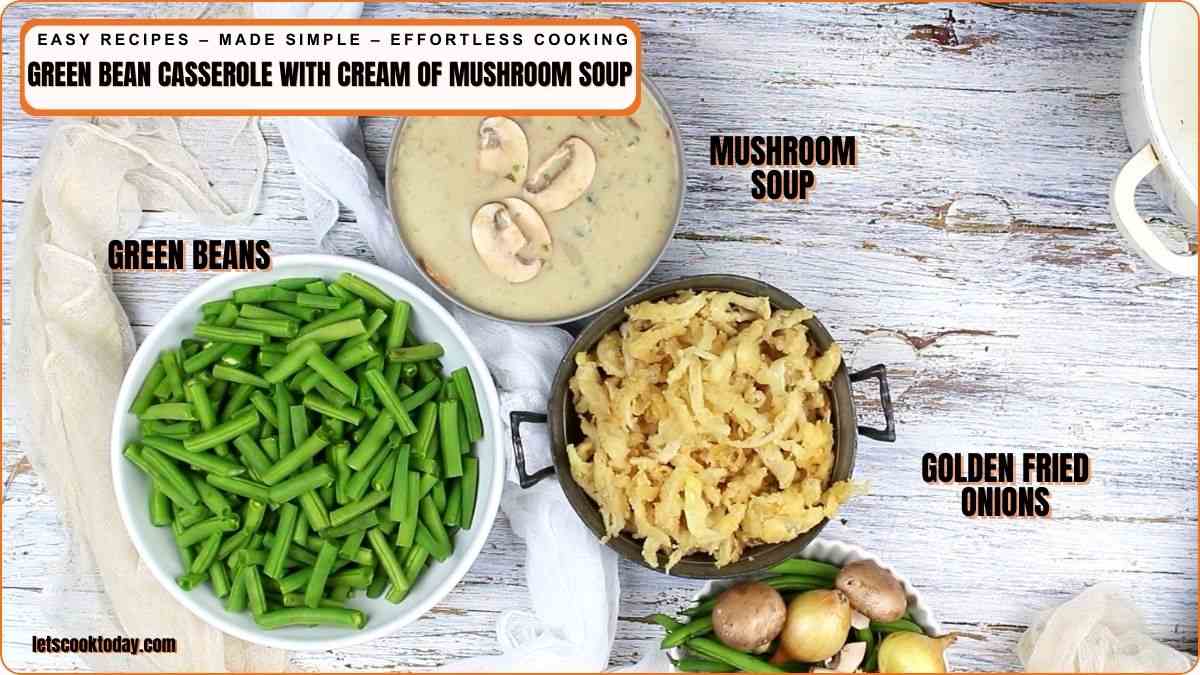 Three bowls containing green beans, cream of mushroom soup with sliced mushrooms, and golden fried onions are arranged on a white wooden surface.