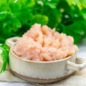 Bowl of ground chicken breast and parsley.