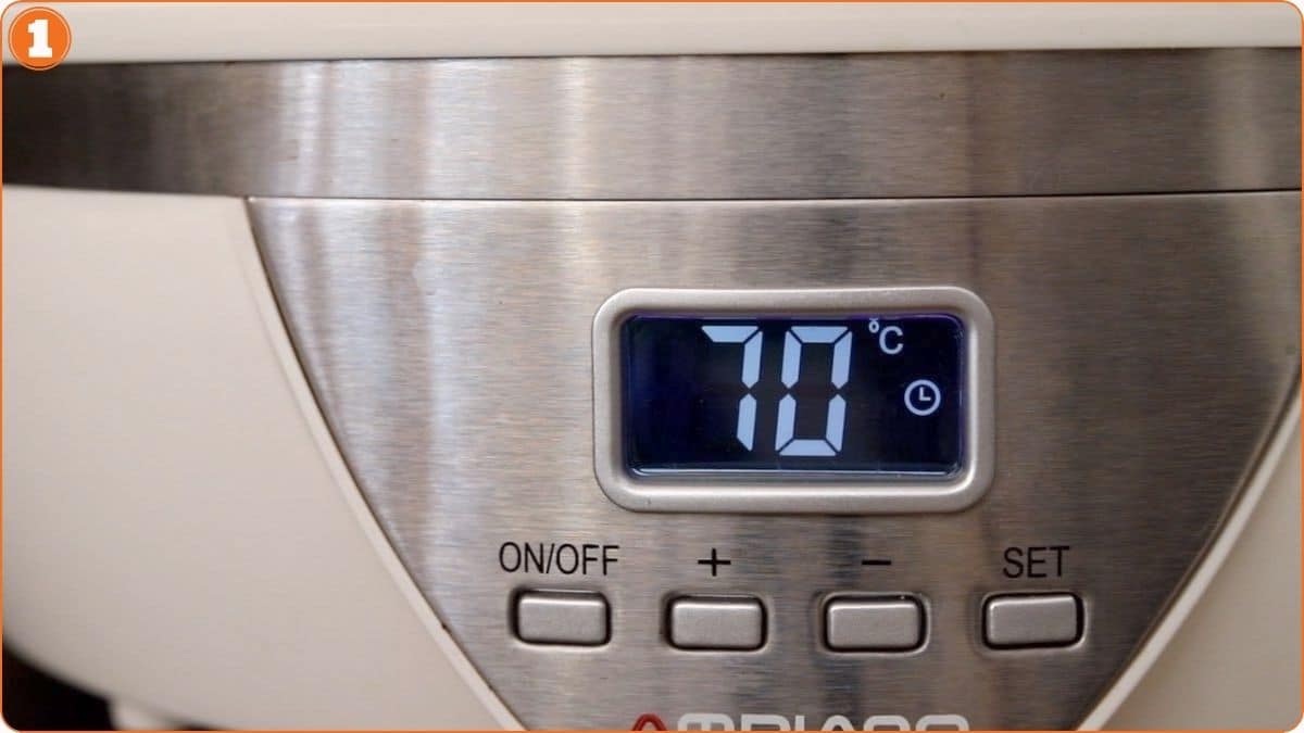 A digital kitchen appliance display shows a temperature of 70°C, with buttons labeled ON/OFF, plus, minus, and SET below the screen.