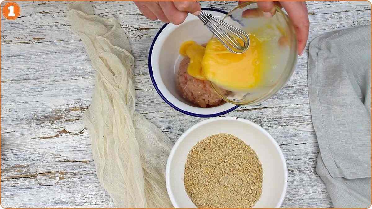 Mixing ground chicken with whisked beaten eggs.