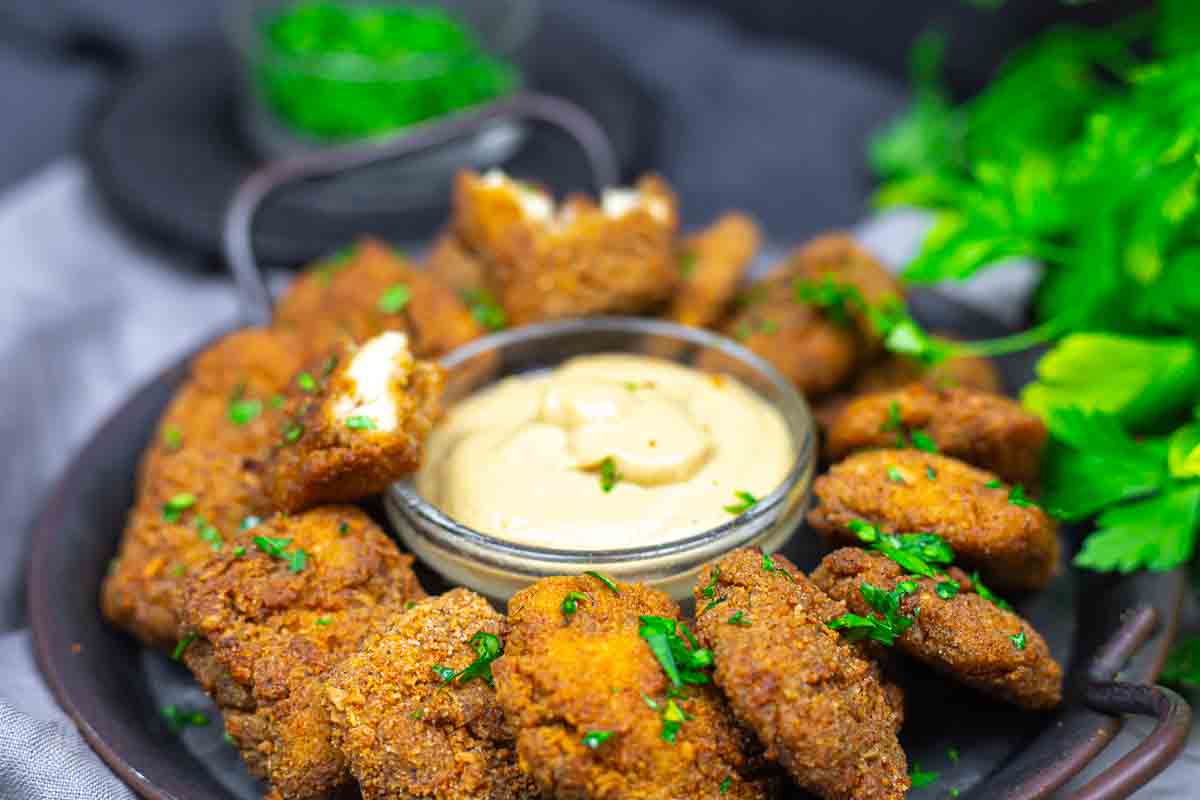 Plate of ground chicken nuggets with sauce.