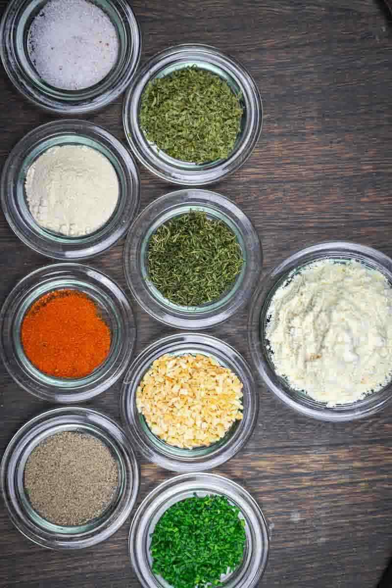 Colorful spices in glass bowls on table.