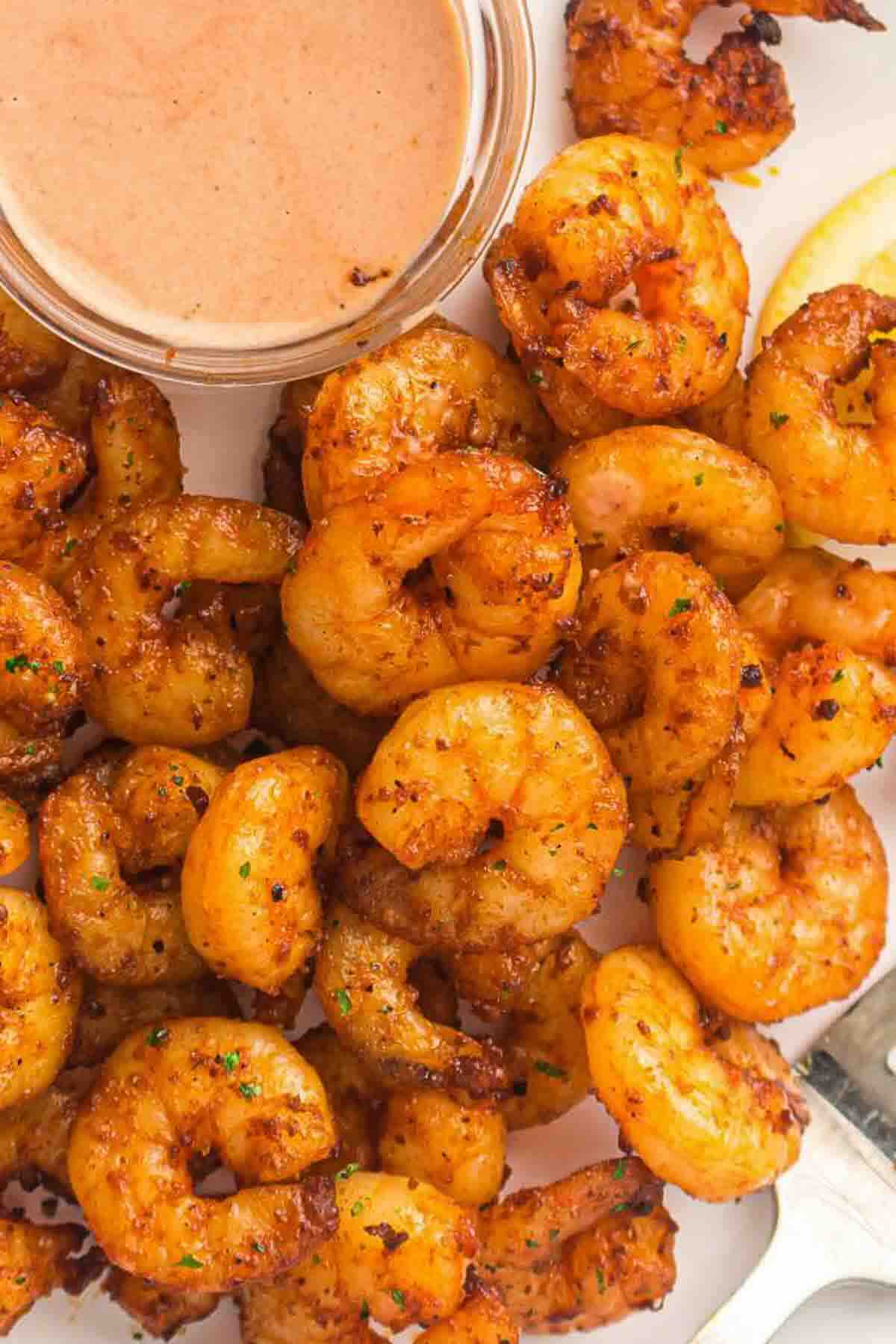 Juicy air fryer shrimp on white plate.