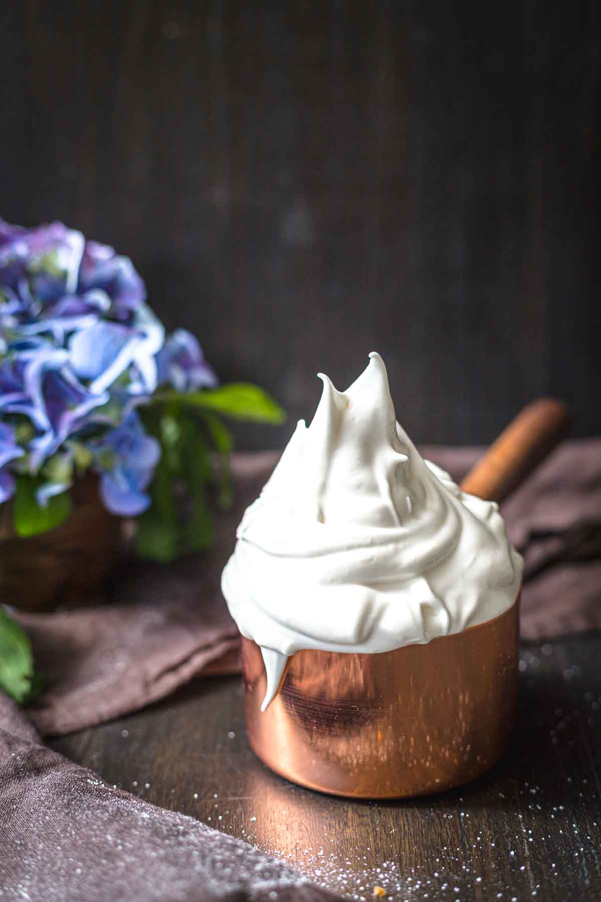 Smooth meringue icing peaks in copper pan.