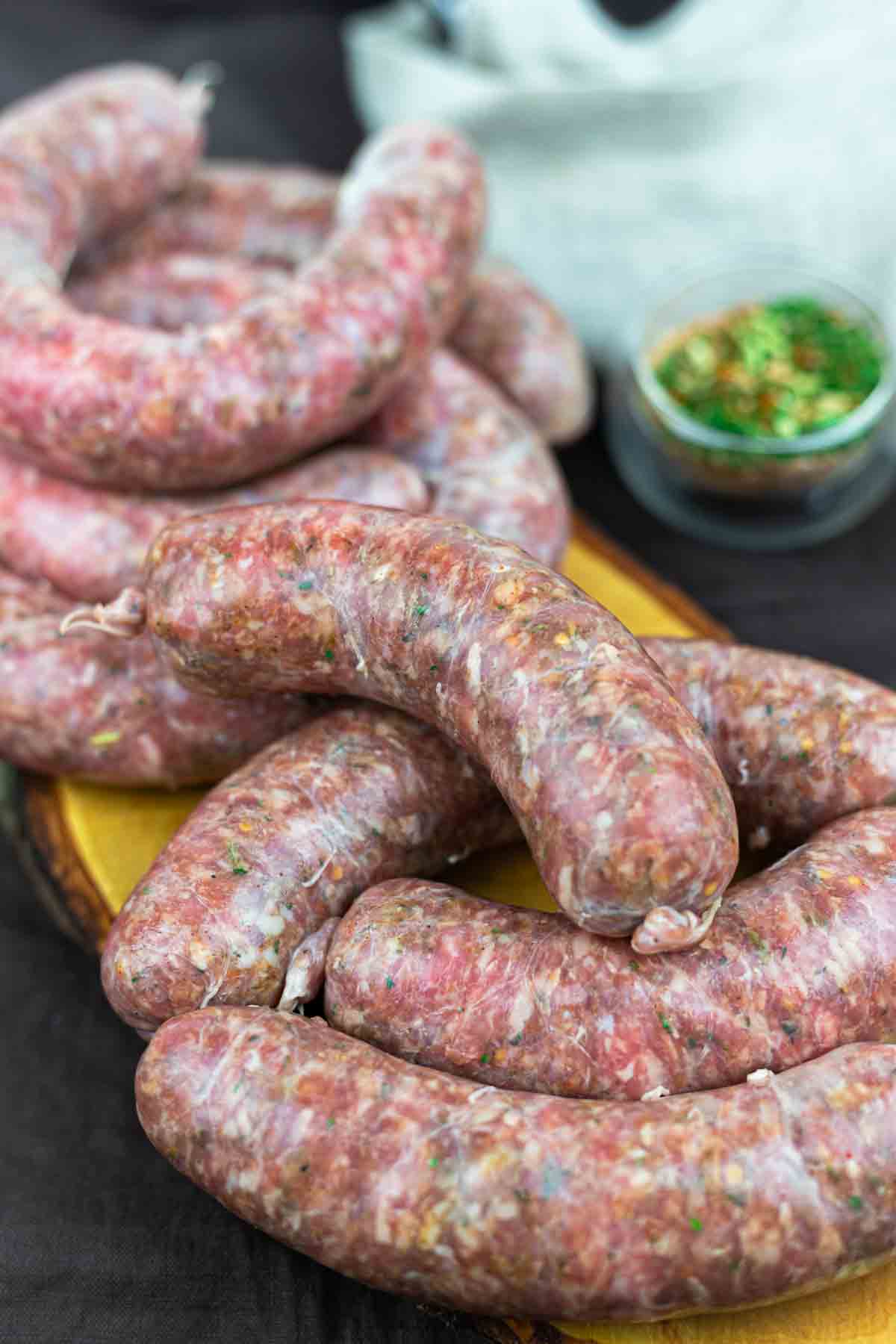 Freshly made sausages arranged on wooden board.