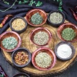 Assorted Italian herbs displayed in small bowls.