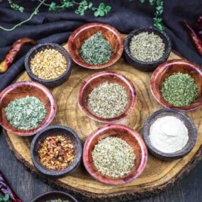 Assorted Italian herbs displayed in small bowls.