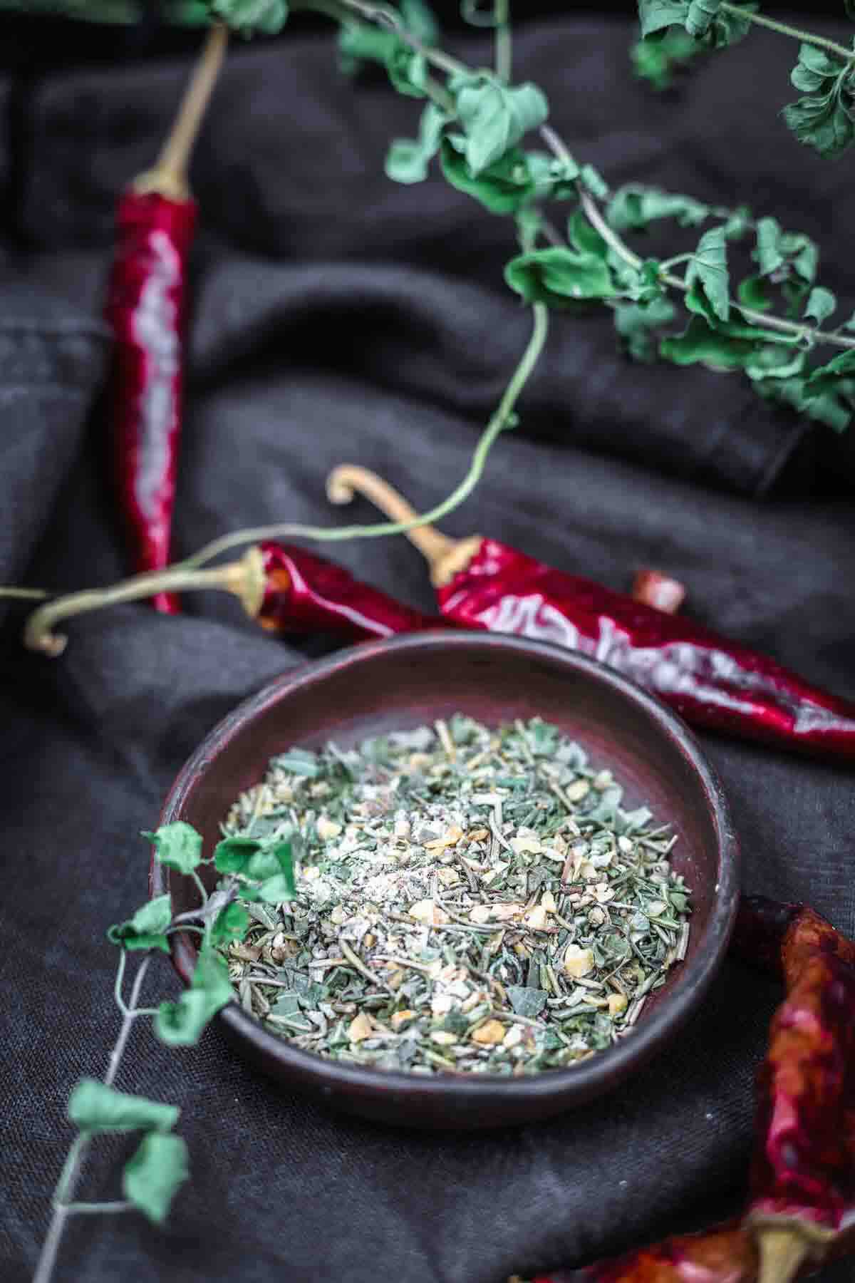 Bowl of Italian seasoning with red peppers.