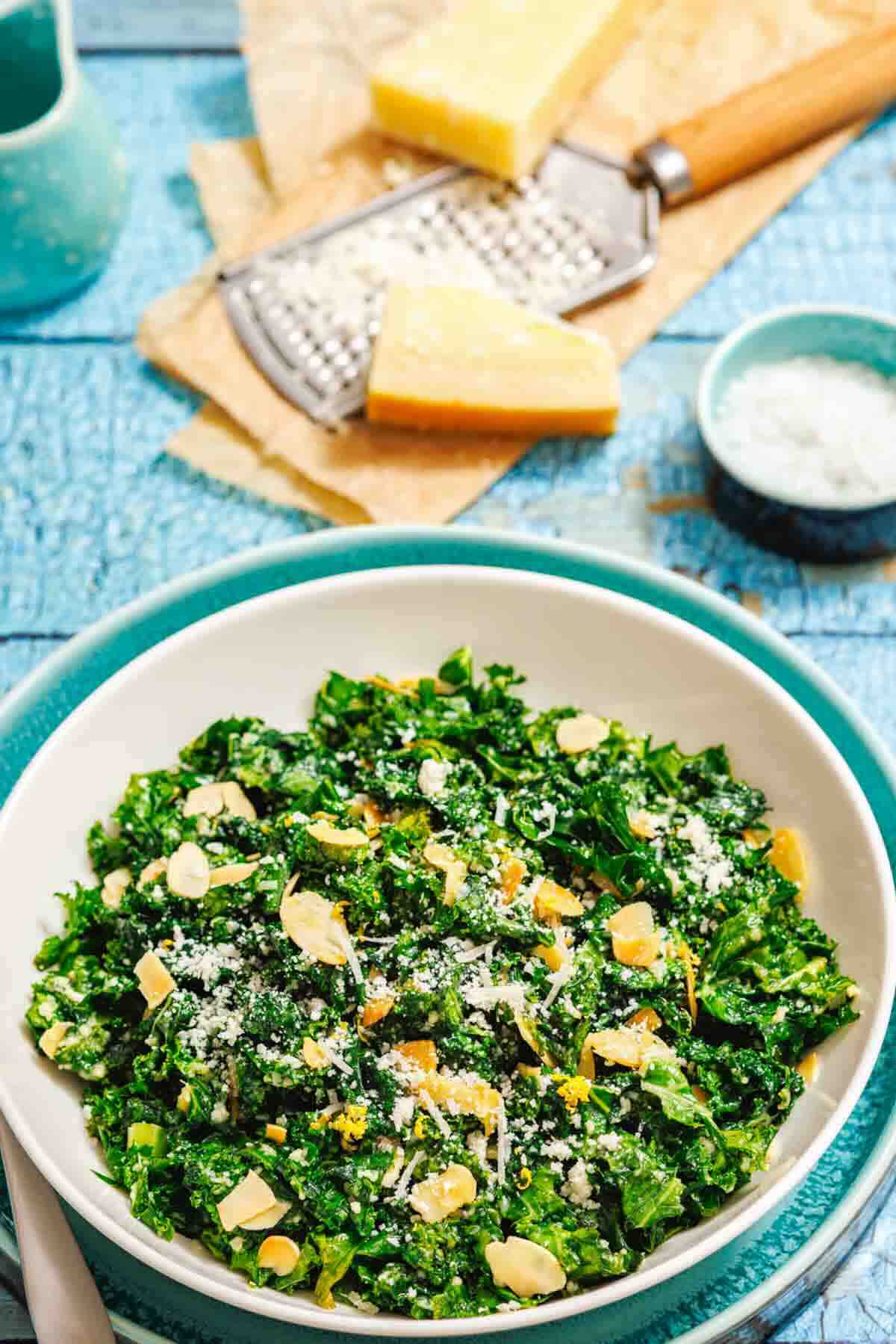 Fresh kale salad topped with parmesan cheese.