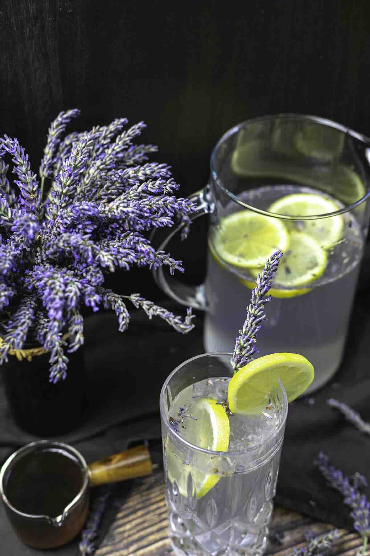 Lavender sprigs beside lemon lavender purple mocktail.
