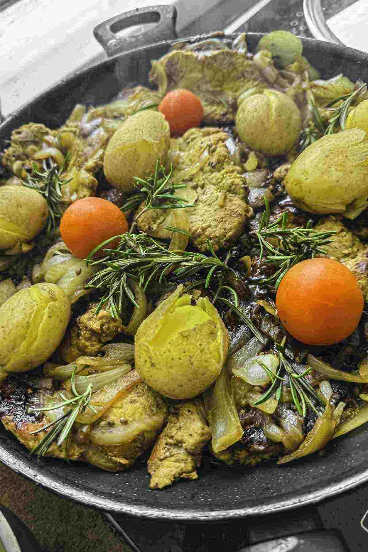 Pan of pork cutlets with onion and potatoes.