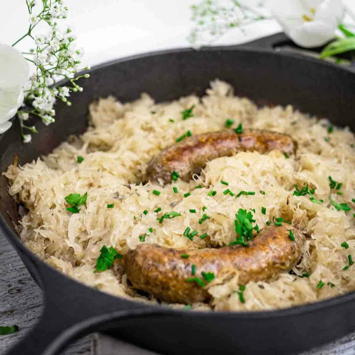 Juicy sausage baked with sauerkraut and herbs.