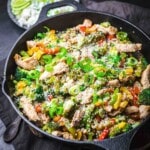 Cast iron pan with chicken and veggies.