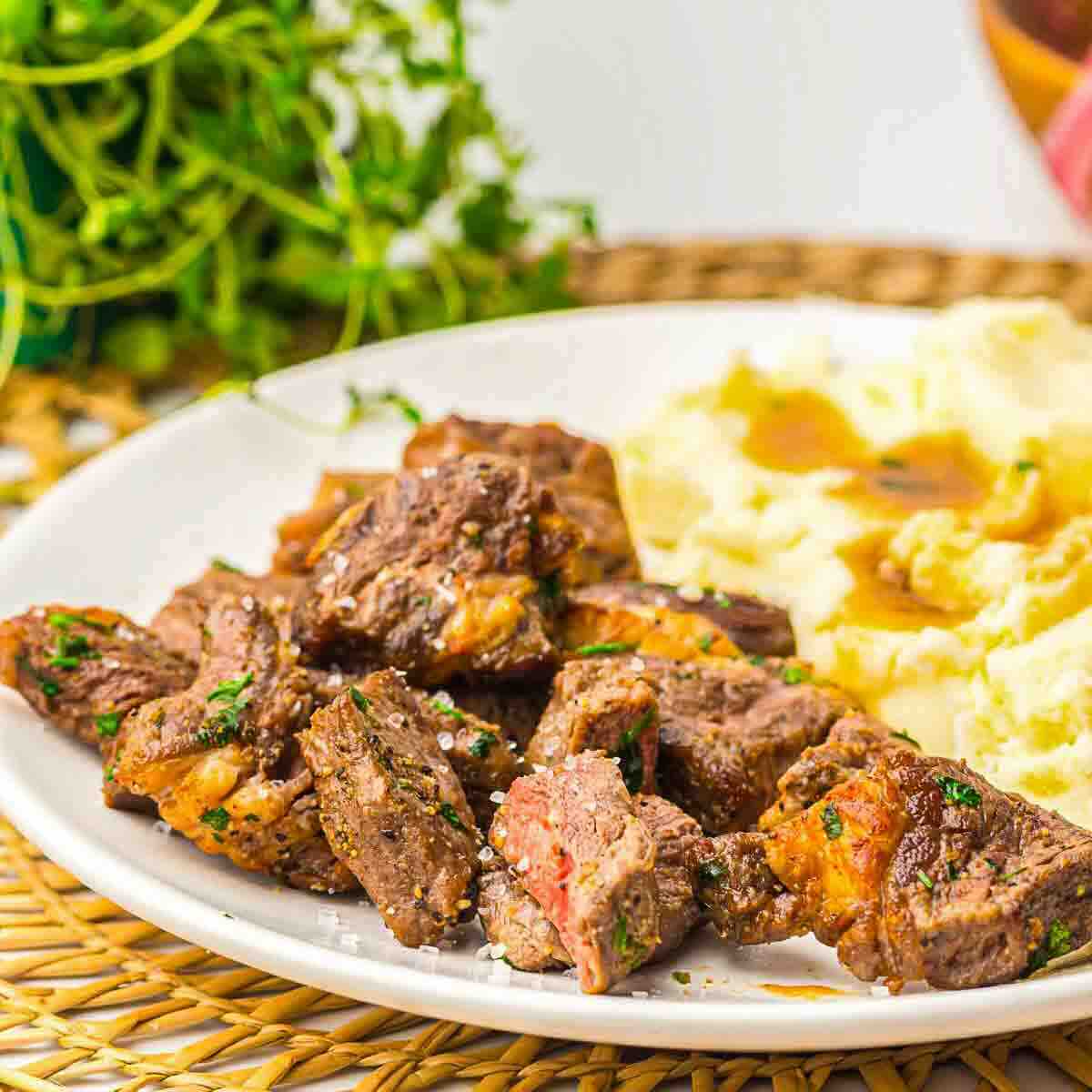Ribeye steak cubes with mashed potatoes side.