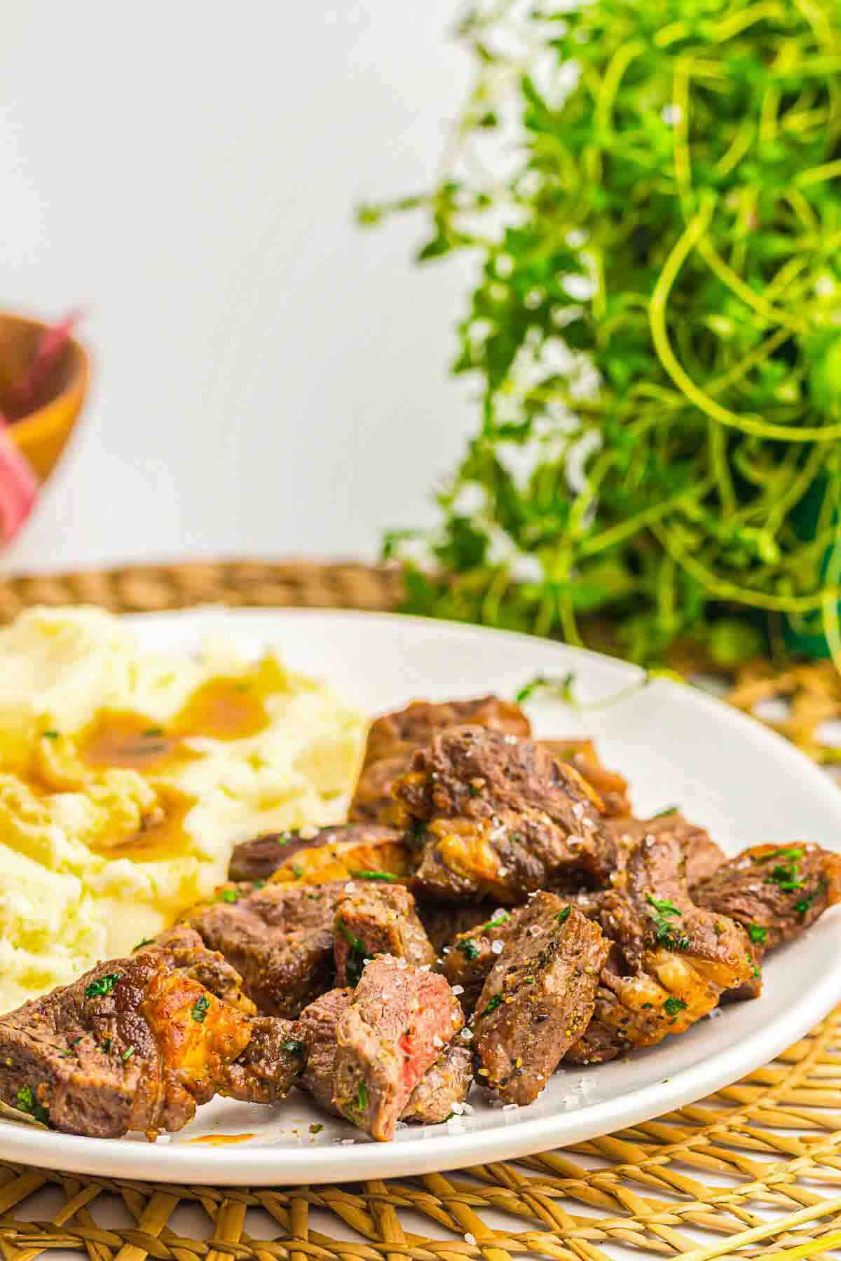 Ribeye steak cubes served with mashed potatoes.