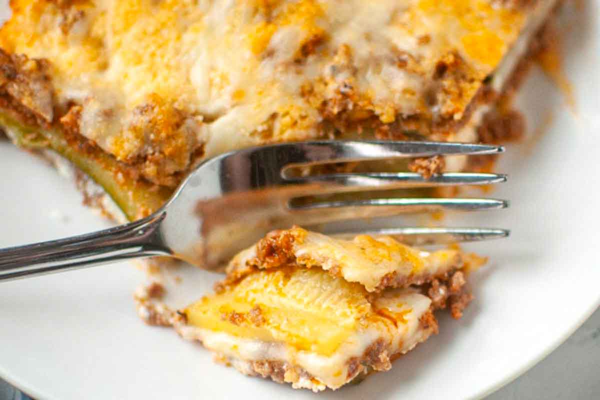 Close-up bite of zucchini lasagna on fork.