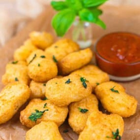 Golden chicken nuggets with dipping sauce bowl.