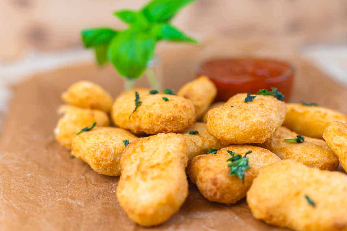 Reheated chicken nuggets with basil and sauce.