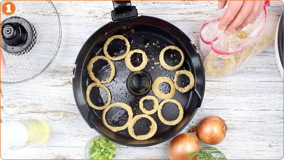 Placing frozen onion rings in air fryer.