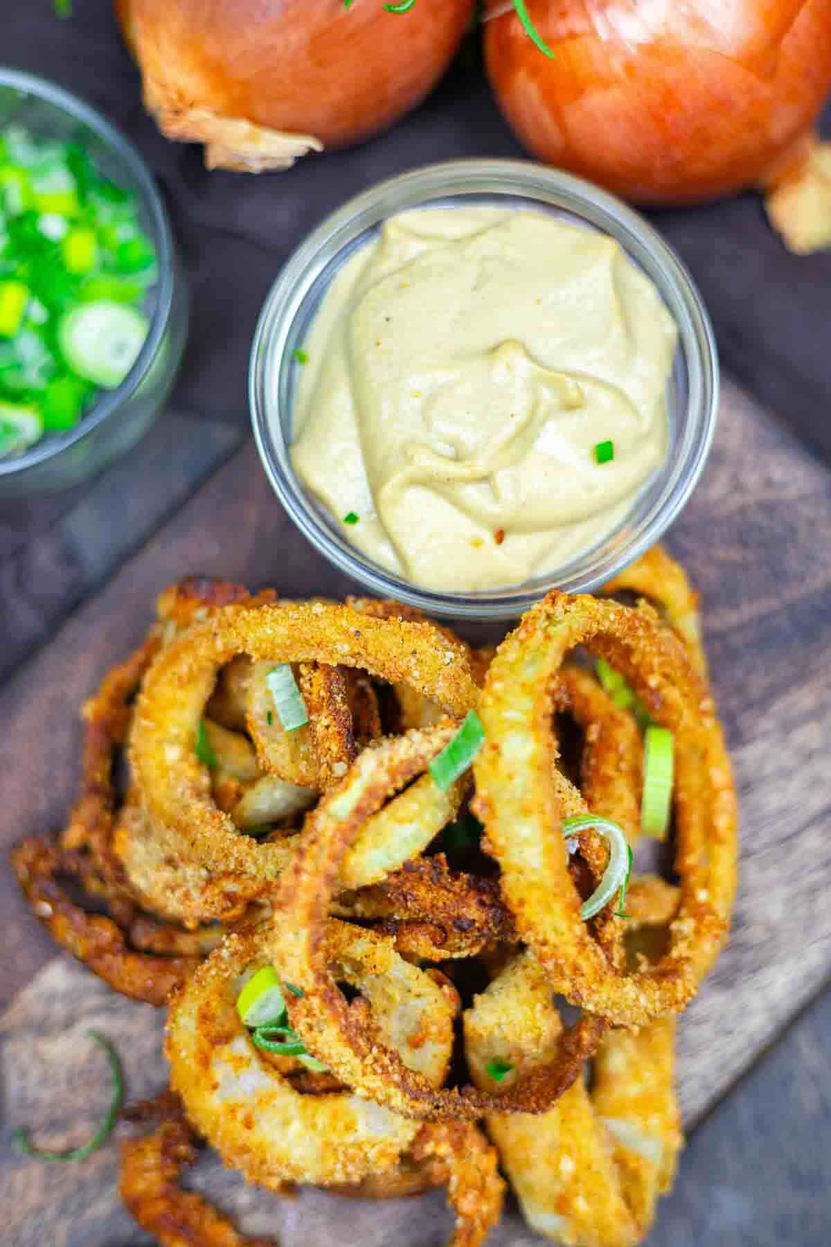 Crispy onion rings garnished with green onions.