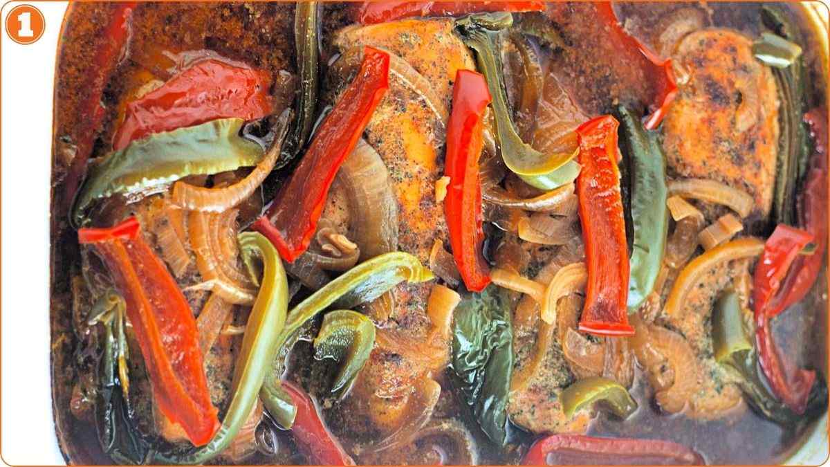 Baked fish fillets topped with sliced red and green bell peppers and onions in a brown sauce.