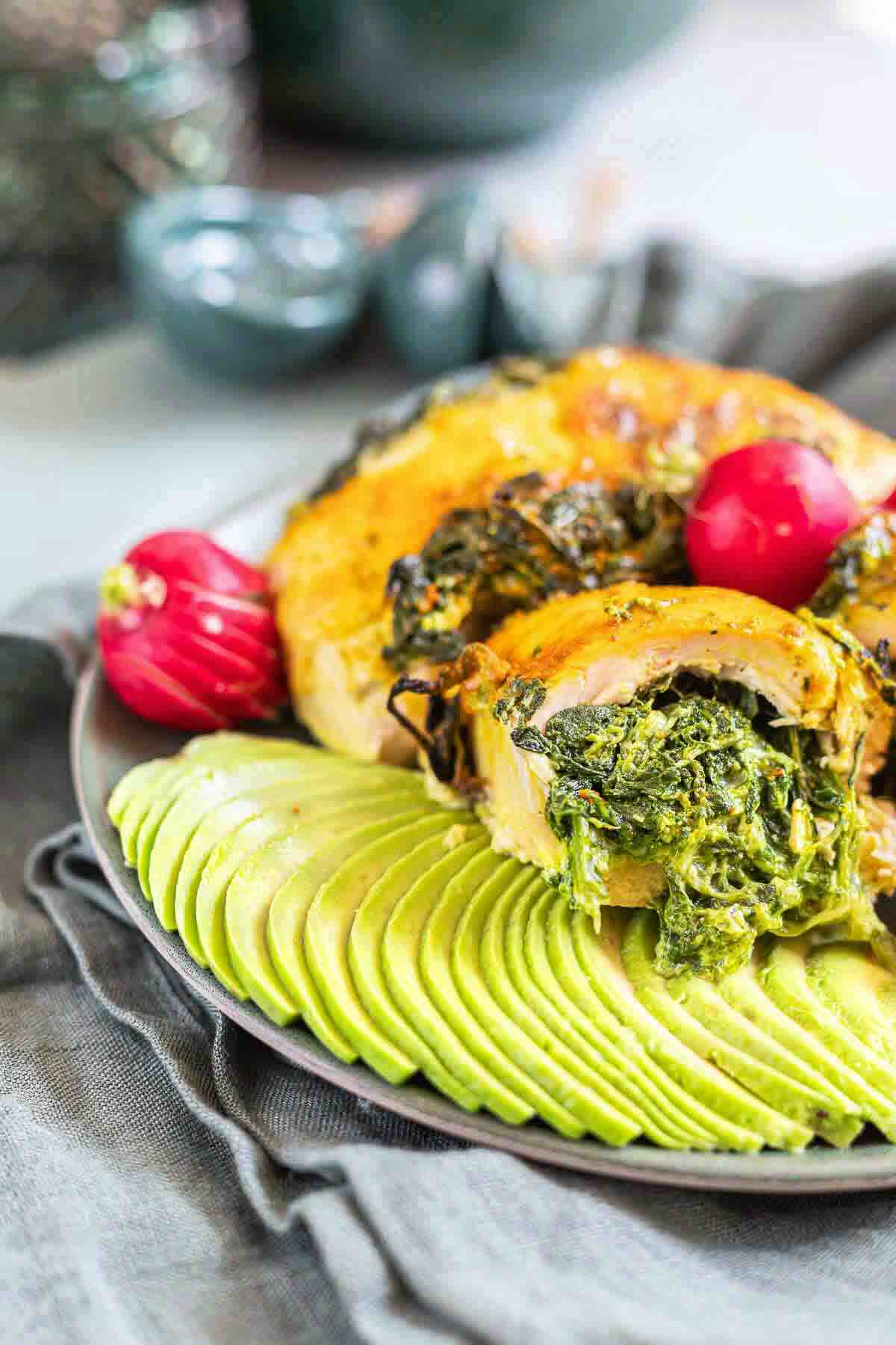 Juicy stuffed chicken rolls served with avocado slices.