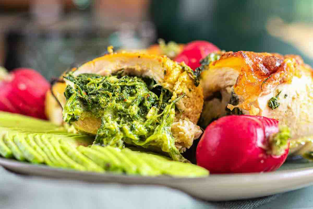 Close-up of cheesy spinach stuffed chicken slices.