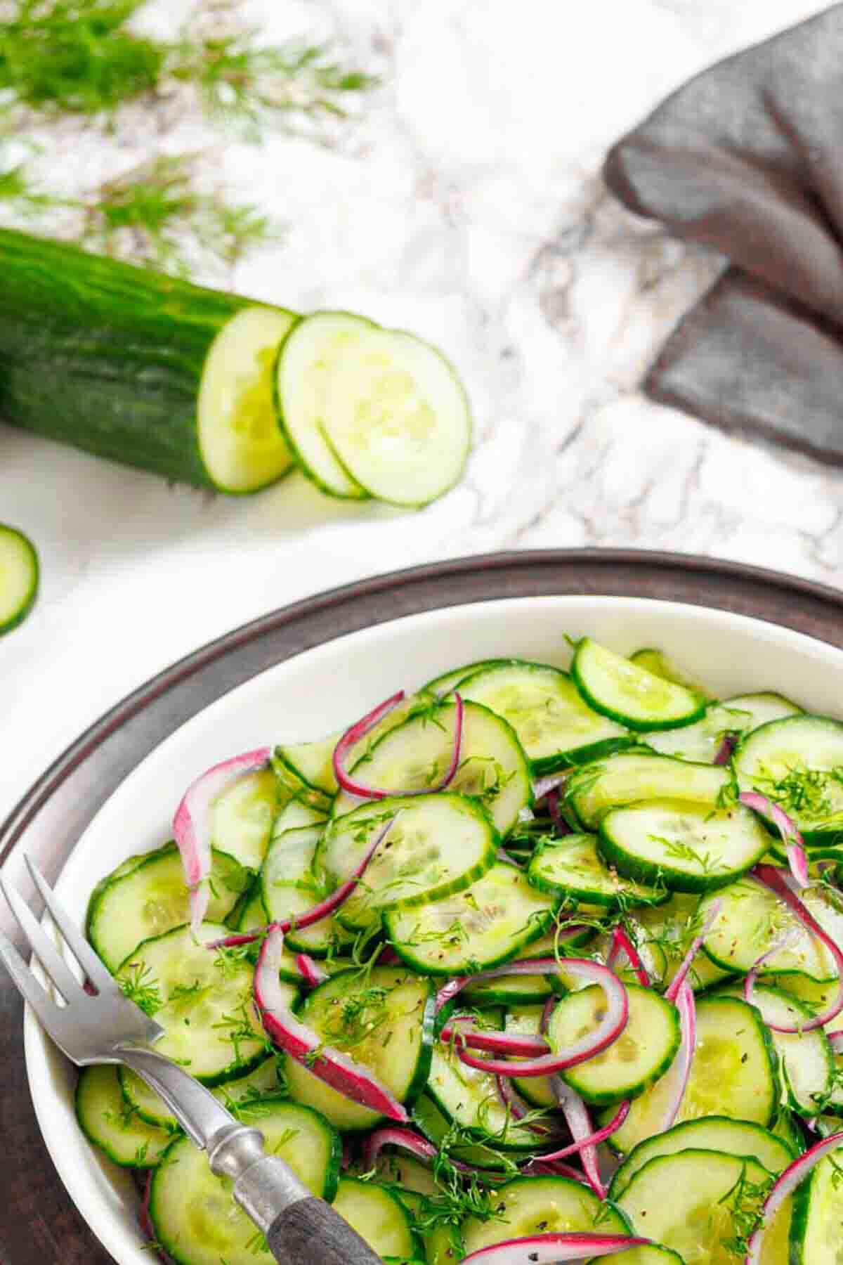 Cucumber and red onion salad on table.