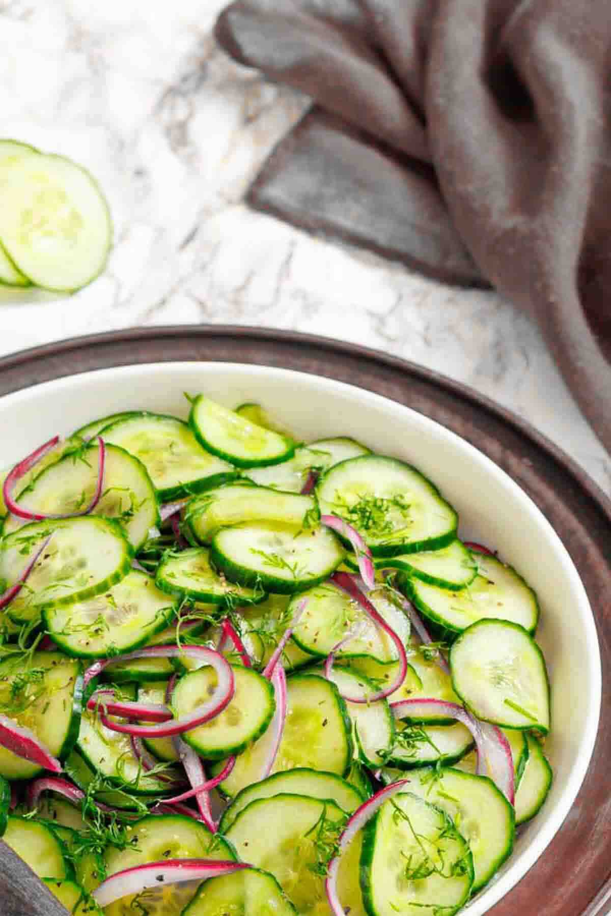 Sliced cucumber and onion salad in bowl.