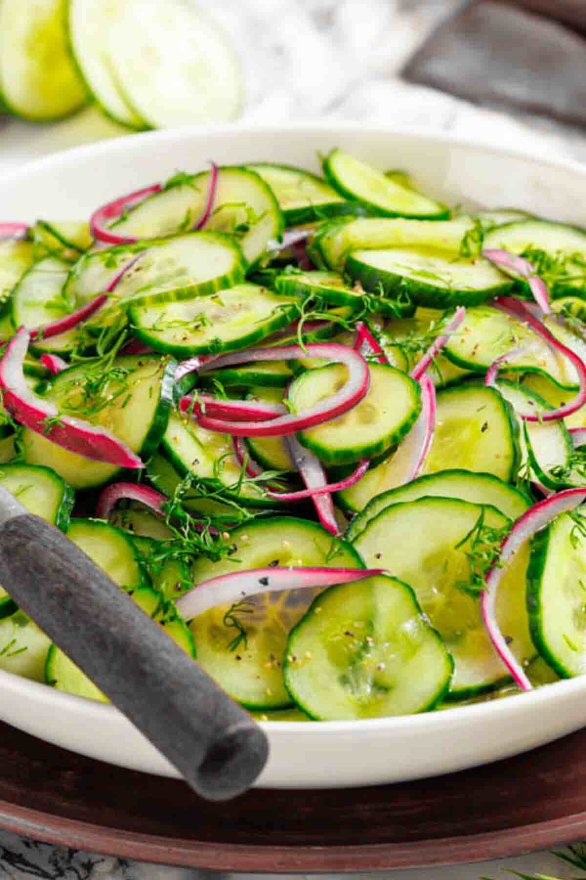 Bowl of vinegar cucumber salad with dill.