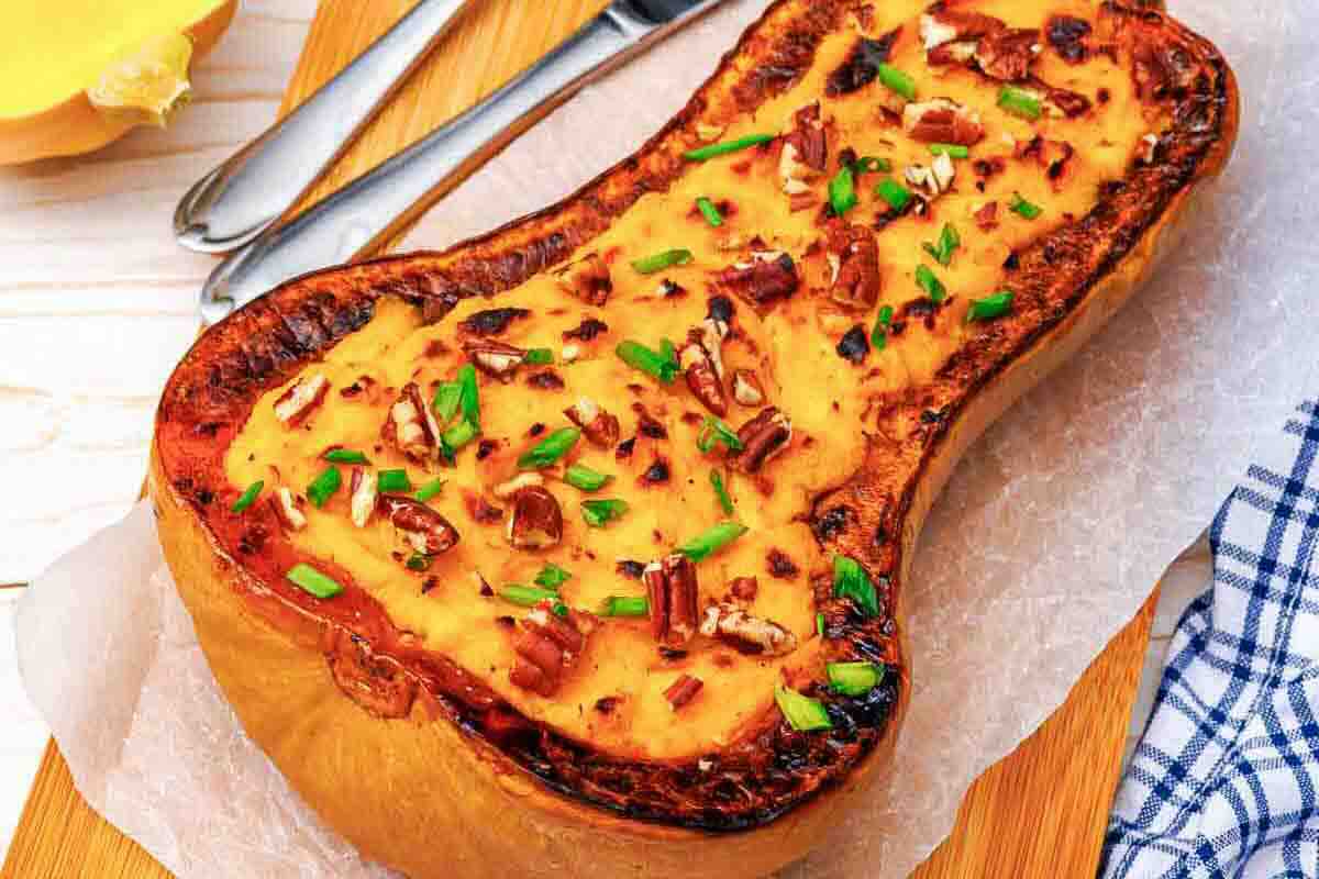 Roasted butternut squash stuffed with a savory filling, topped with pecans and chives.